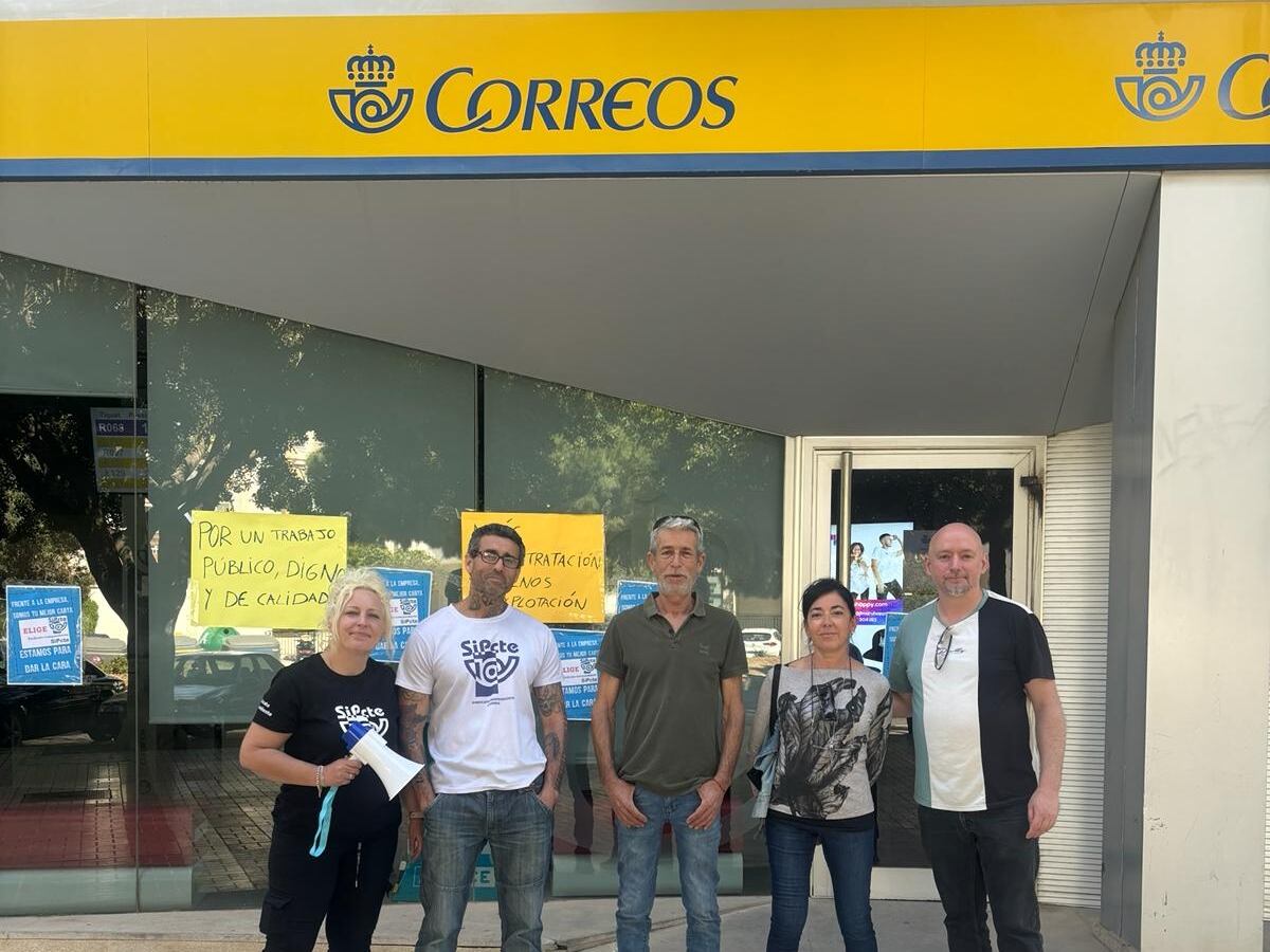 Carmen Hurtado con sus compañeros sindicales ante la oficina donde trabaja en Málaga