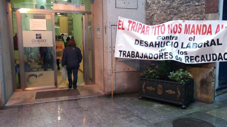 Pancarta de los trabajadores en huelga de La Auxiliar de Recaudación, colocada a la entrada de la oficina municipal de recaudación, donde los ciudadanos que esperaban llegaban hasta la puerta del local.