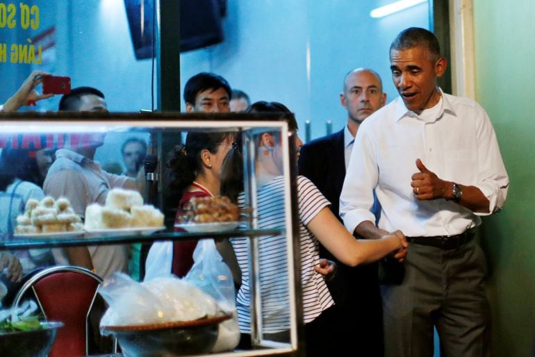 El presidente de EE UU, Barack Obama, saluda a un chica vietnamita después de comer con Anthony Bourdain en un restaurante de Hanoi, el pasado lunes, 23 de mayo.