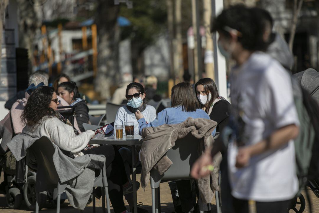 Ciudadanos en la calle disfrutando del sol en una terraza, haciendo uso de las mascarillas 