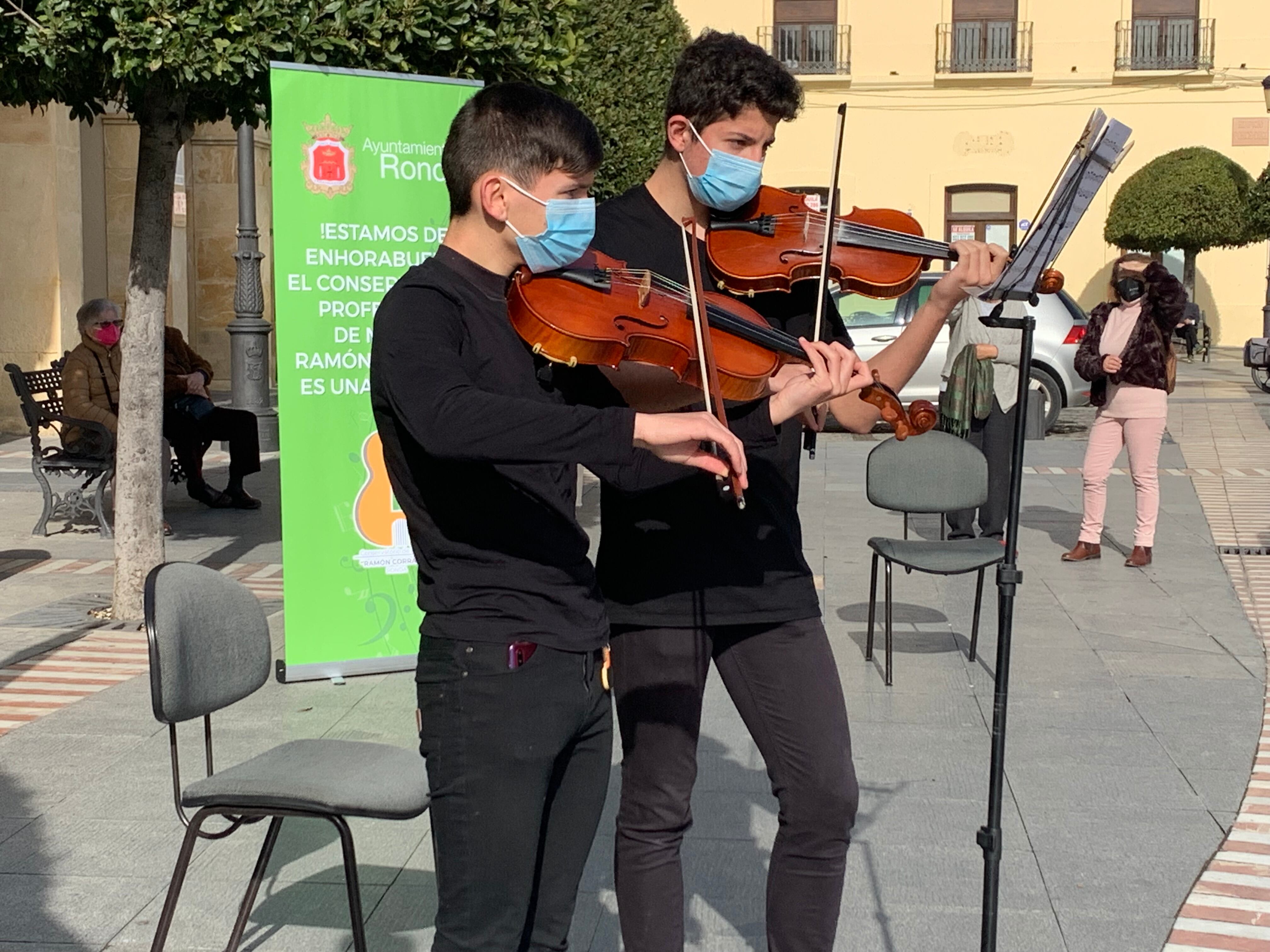 Dos alumnos del conservatorio de Ronda interpretan una pieza musical en la plaza de España