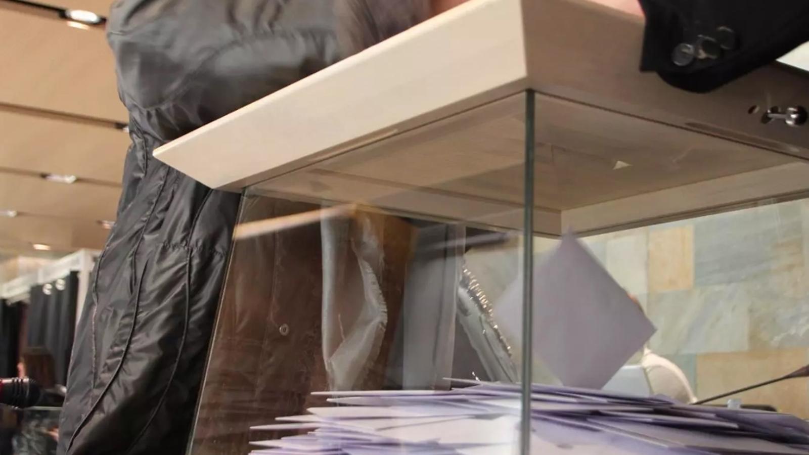 Una persona diposita el vot a l'urna