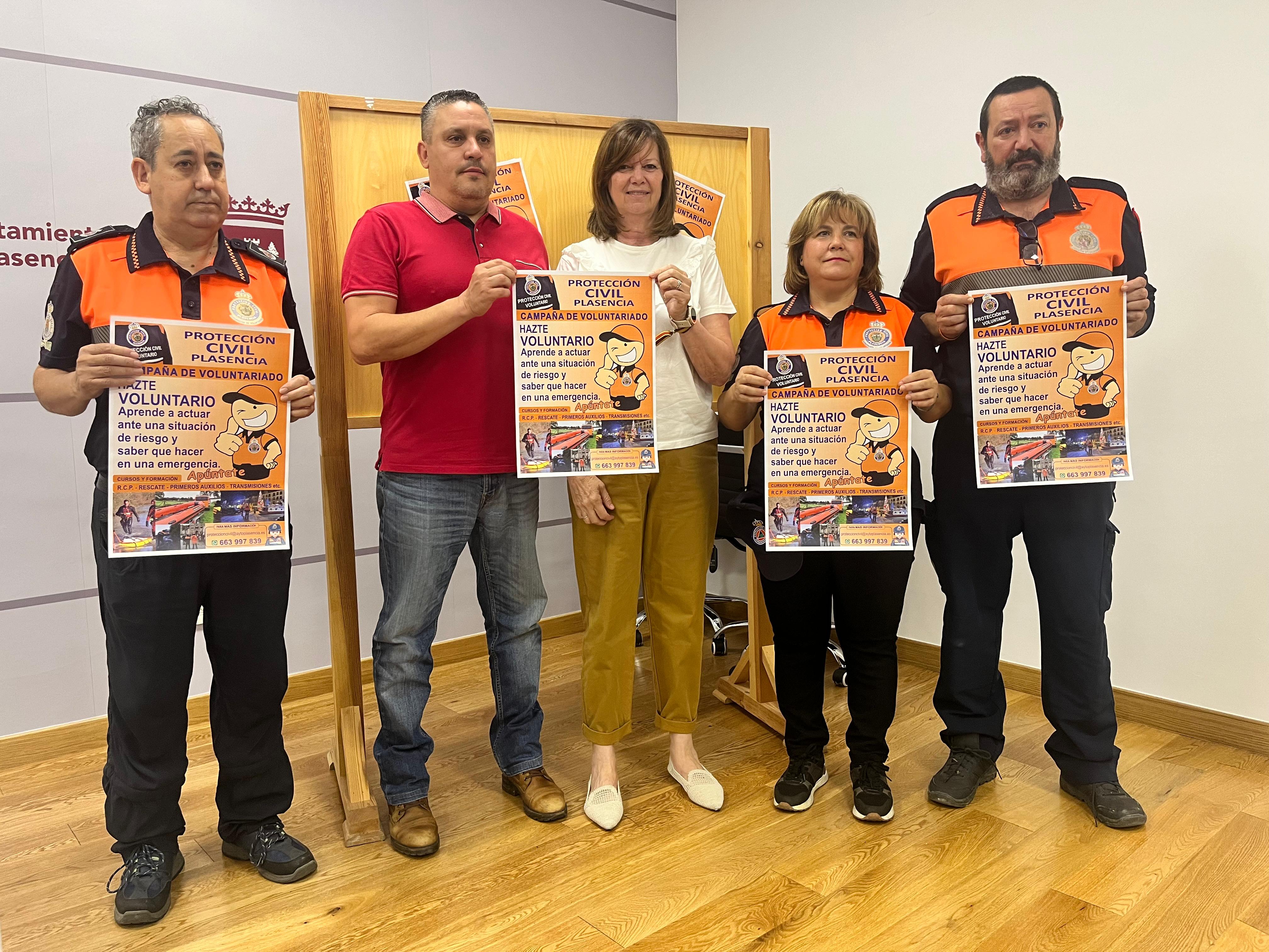 Miembros de Protección Civil de Plasencia con el cartel de la campaña.