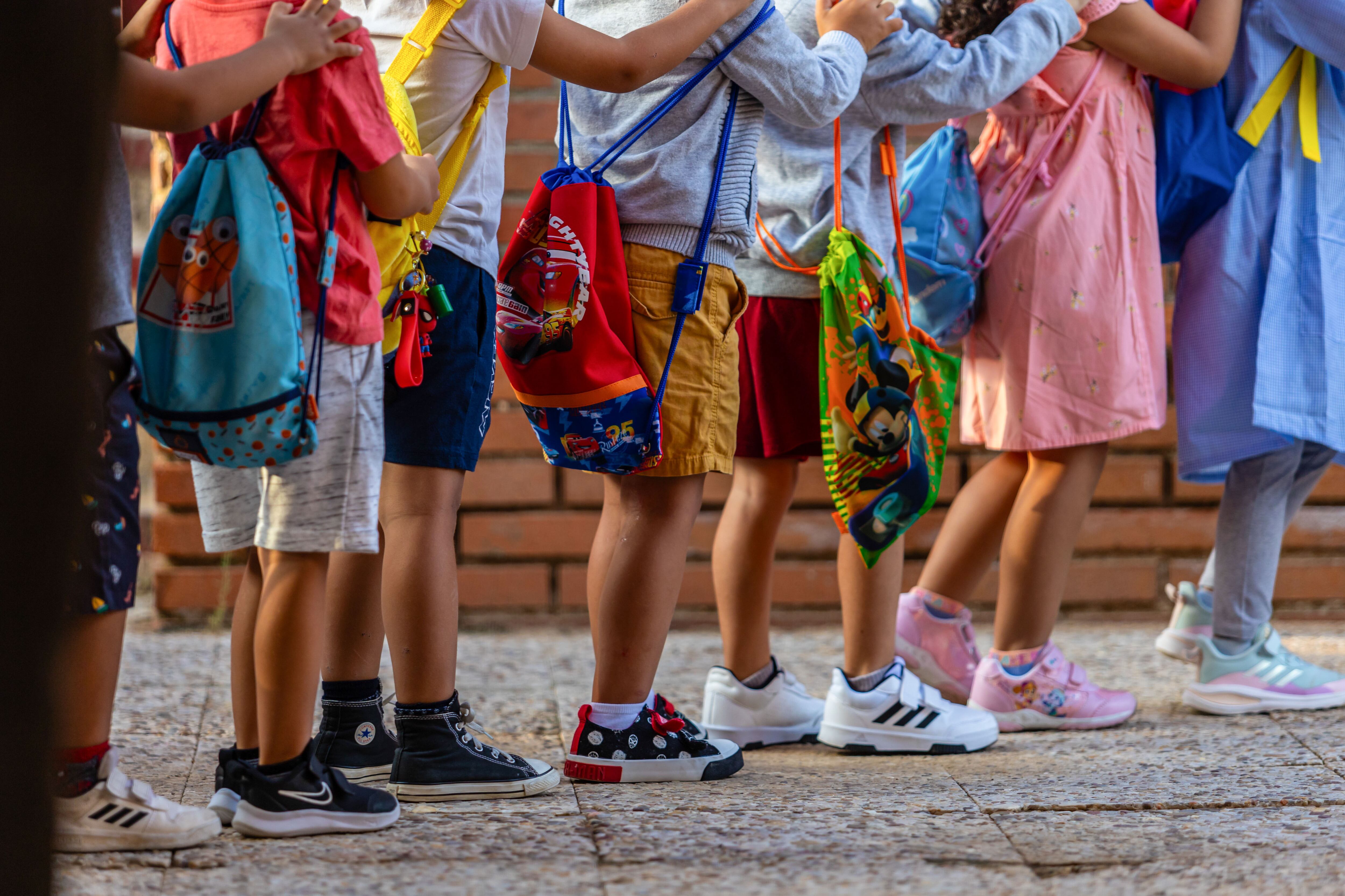TOLEDO, 11/09/2023.- Niños del colegio Aquisgran de Toledo a su llegada al centro en el día que marca el inicio del curso escolar en Castilla-La Mancha. Más de 389.991 alumnos de Castilla-La Mancha vuelven a clase este lunes en 1.753 centros educativos sostenidos con fondos públicos, un curso que estará marcado por la innovación educativa a través de la robótica, pensamiento computacional y programación, así como por la nueva ley educativa, que este año se aplica en los cursos pares. EFE/Ángeles Visdómine
