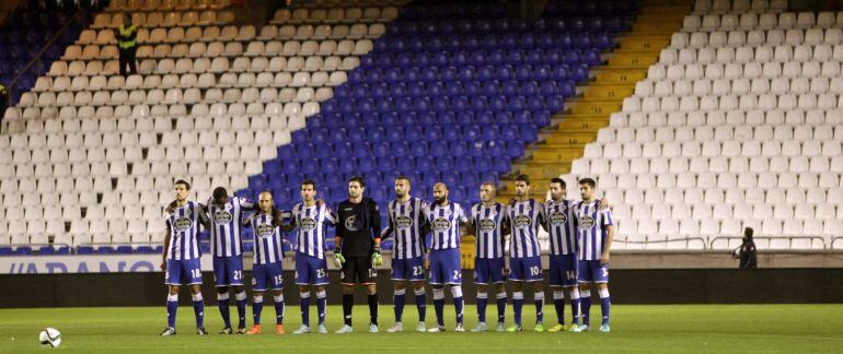 Los jugadores del Deportivo guardan un minuto de silencio por la muerte del aficionado que falleció el domingo en una reyerta entre ultras del equipo coruñes y el Atlético de Madrid, con la grada en la que se ubican los Riazor Blues vacía.