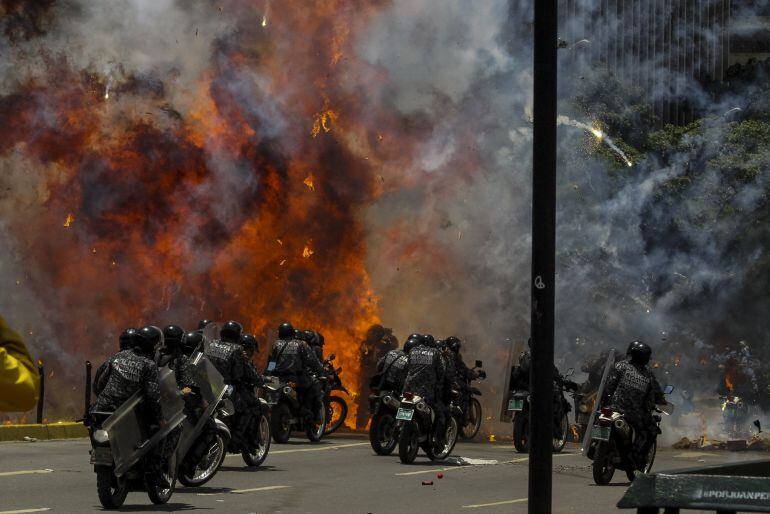 Fotografía de una explosión en medio de varios policías motorizados en las inmediaciones de la Plaza Altamira de Caracas (Venezuela)