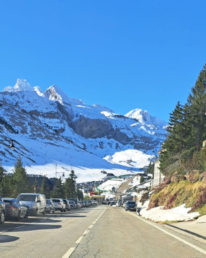 Día de lleno en las estaciones de esquí, con vehículos aparcados también junto a la carretera