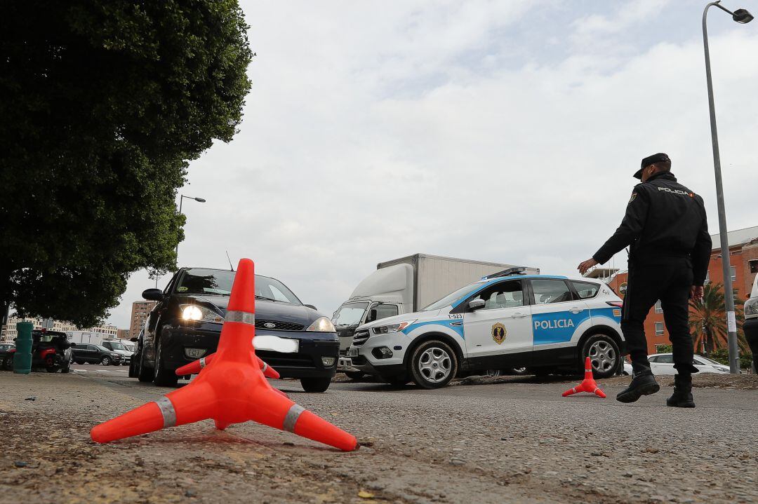 Un policía detiene a un vehículo en uno de los controles sobre los coches que abandonan la ciudad en pleno estado de alarma 