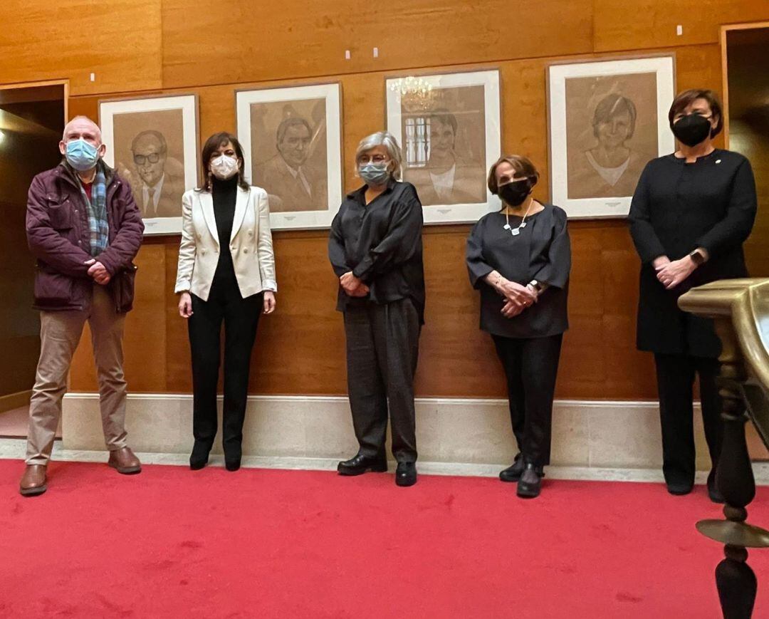 Armando Nosti, Marisol Saavedra, Ana González, Paz Fernández Felgueroso y Carmen Moriyón posan junto a los retratos en las escaleras principales del ayuntamiento de Gijón.