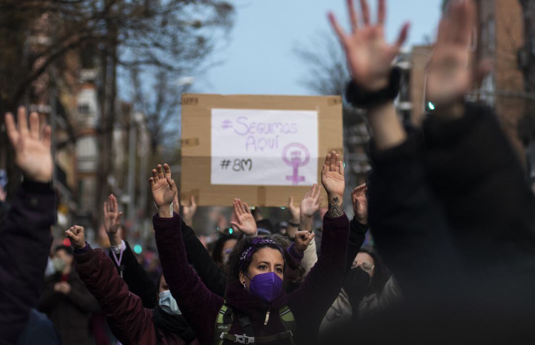 Mujeres levantando las manos en un acto feminista por el Día de la Mujer en Vallecas.