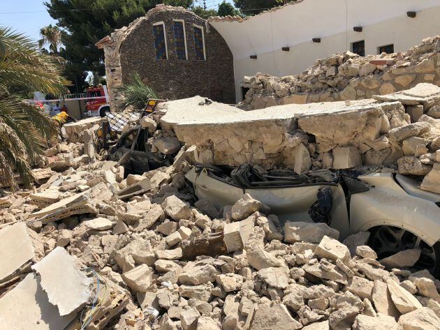 Coche aplastado por el derrumbe del techo y de las paredes de la iglesia de la Coveta Fumà