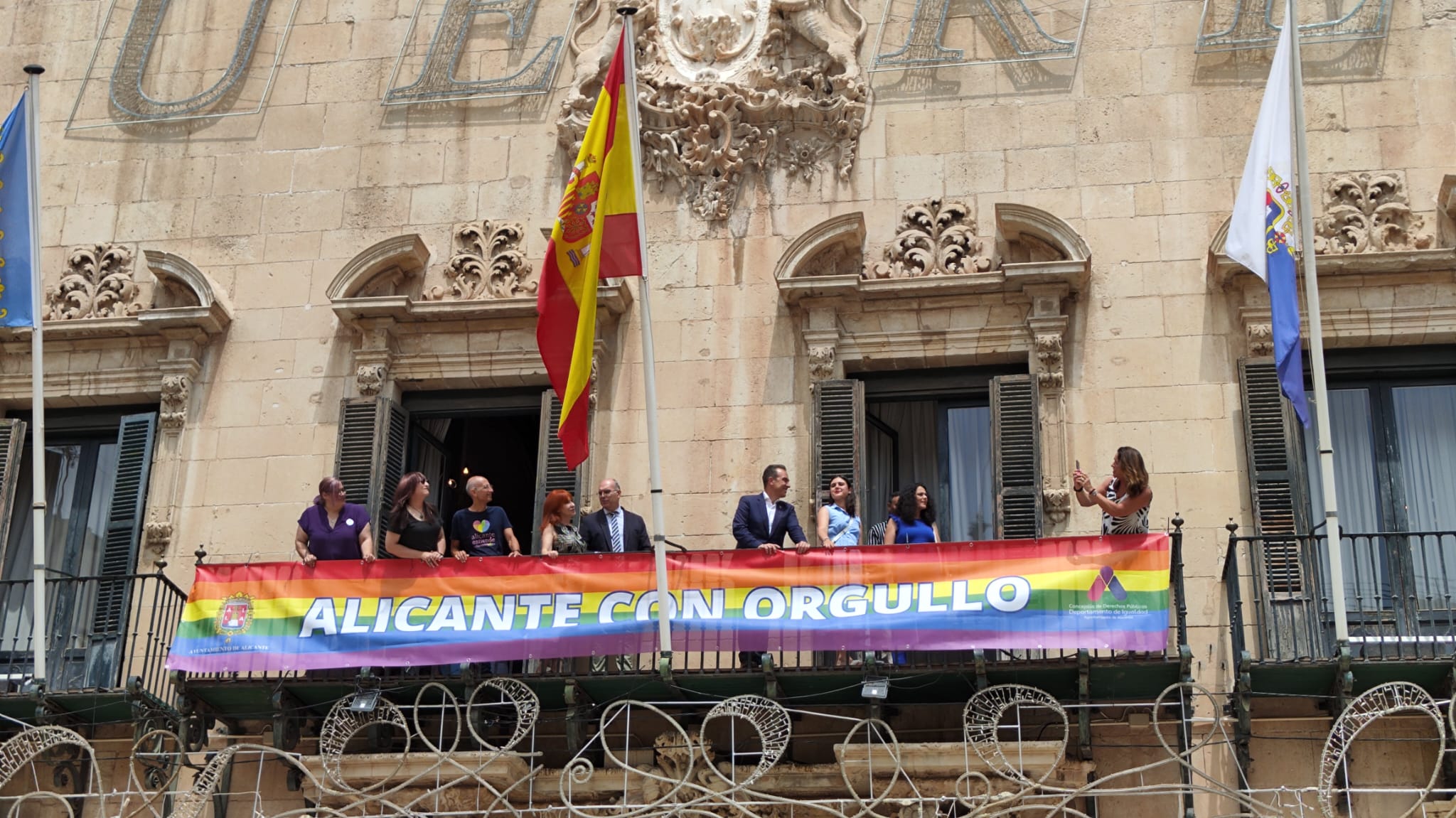 El PP desplegando la bandera LGTBI en el balcón del Ayuntamiento de Alicante acompañado solo por las asociaciones