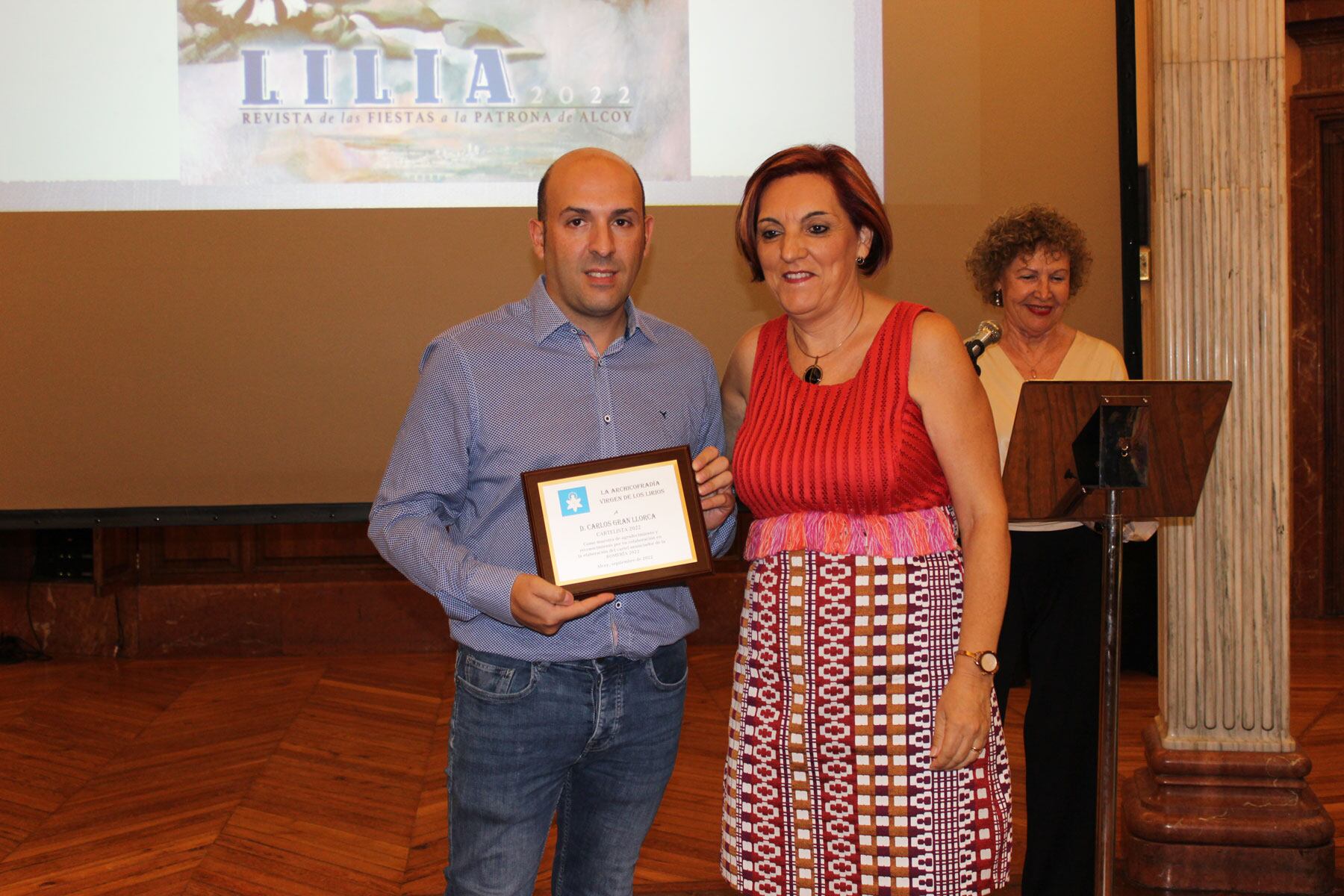 Reme Perelló le entrega un obsequio a Carlos Gran, autor del cartel de la Romería