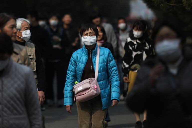 Varios turistas se protegen con mascarillas mientras visitan Pekín (China) porque las autoridades de esta ciudad han emitido una alerta naranja, la segunda más alta, debido a los altos niveles de contaminación del aire. 