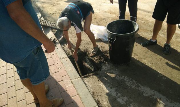 Vecinos de Santo Ángel limpiando un sumidero que había quedado atascado por las lluvias.