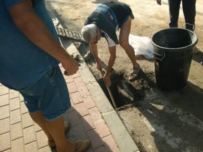Vecinos de Santo Ángel limpiando un sumidero que había quedado atascado por las lluvias.