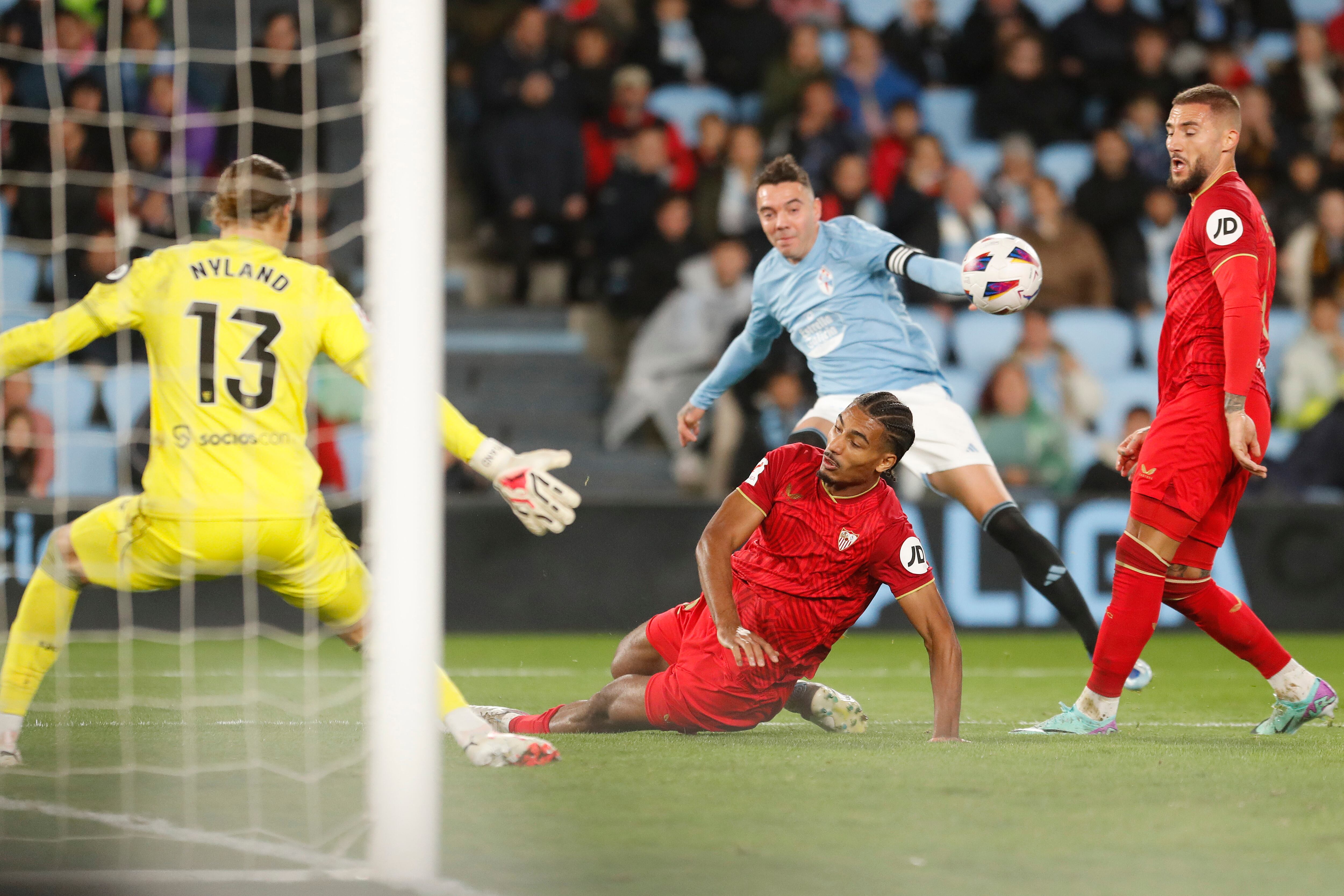 Vigo (Pontevedra) 04/11/2023.- El delantero del Celta de Vigo Iago Aspas (2d) disputa una posesión ante Loïc Badé (suelo) defensa francés del Sevilla durante el partido de la jornada 12 de LaLiga celebrado este sábado en el Estadio de Abanca Balaídos. EFE/Salvador Sas
