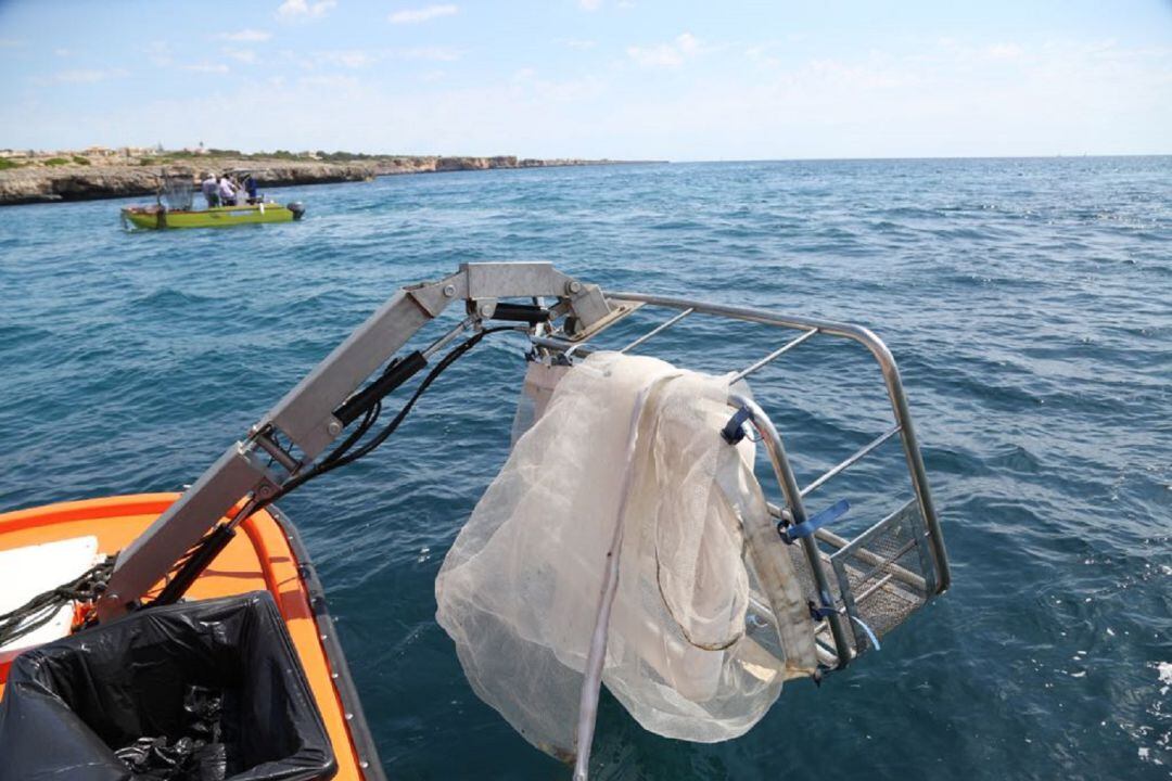 Una de las embarcaciones retirando residuos del mar