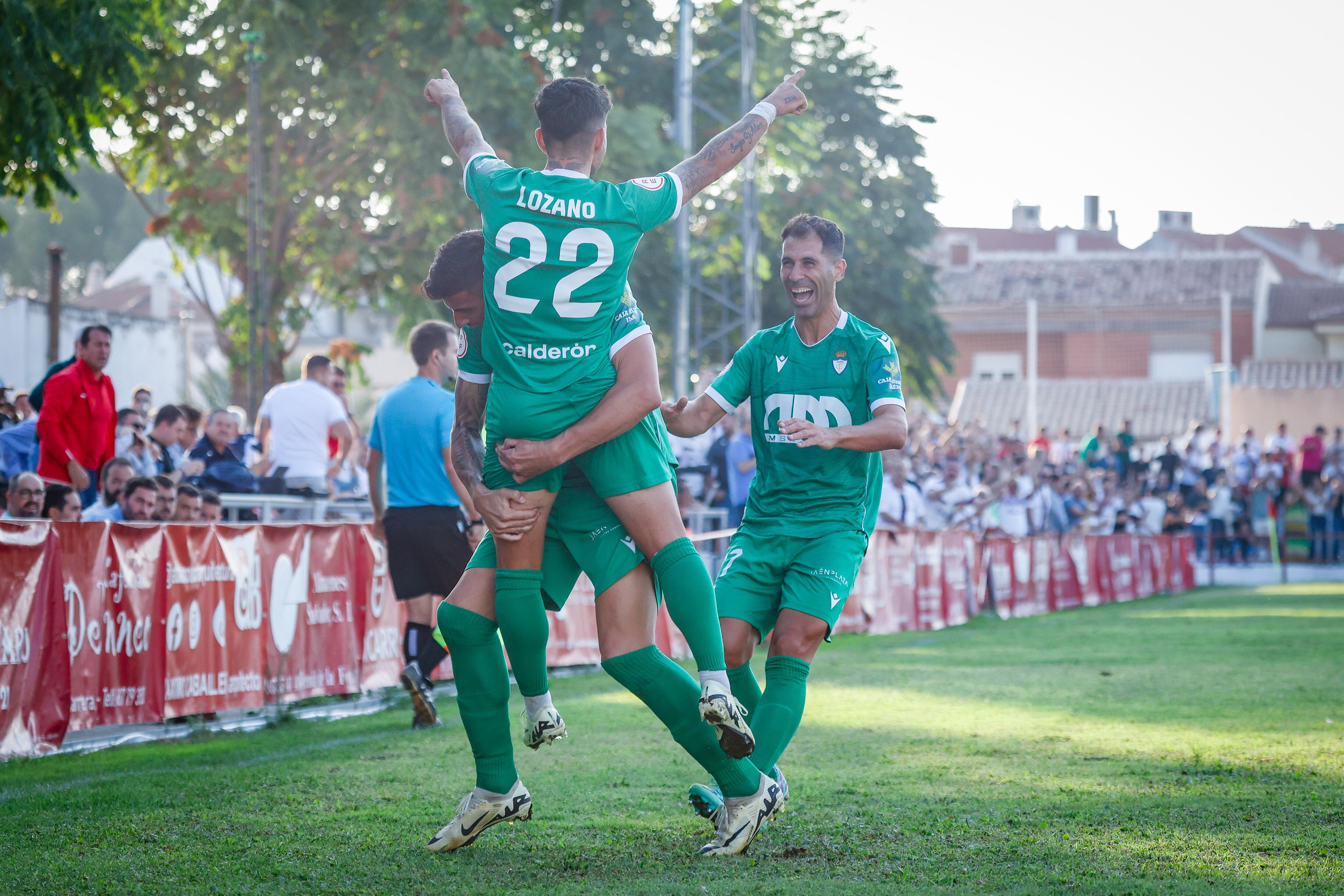 Óscar Lozano, de espaldas, celebra un gol en Martos con el Real Jaén.