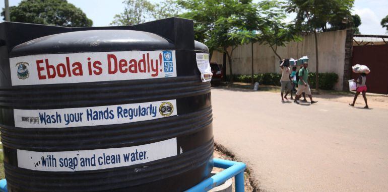 MRV02. Monrovia (Liberia), 01/08/2015.- Liberians walk pass a public tank filled with chloronated water to curb the spread of the deadly ebola virus in Monrovia, Liberia, 01 August 2015. Chloronayed water in Tanks, buckets, and containers are being placed