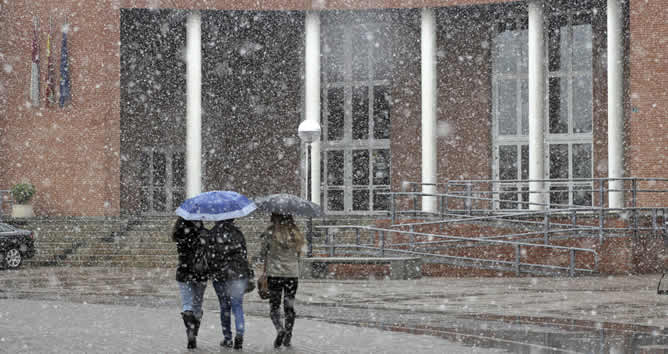 Varias estudiantes recorren el Campus de la Universidad de Albacete, ciudad que ha recibido la primavera con la primera nevada del año