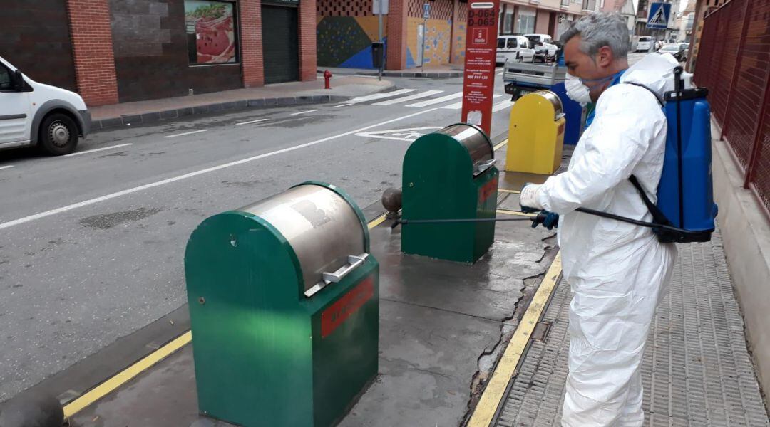 Un técnico desinfecta unos contenedores soterrados