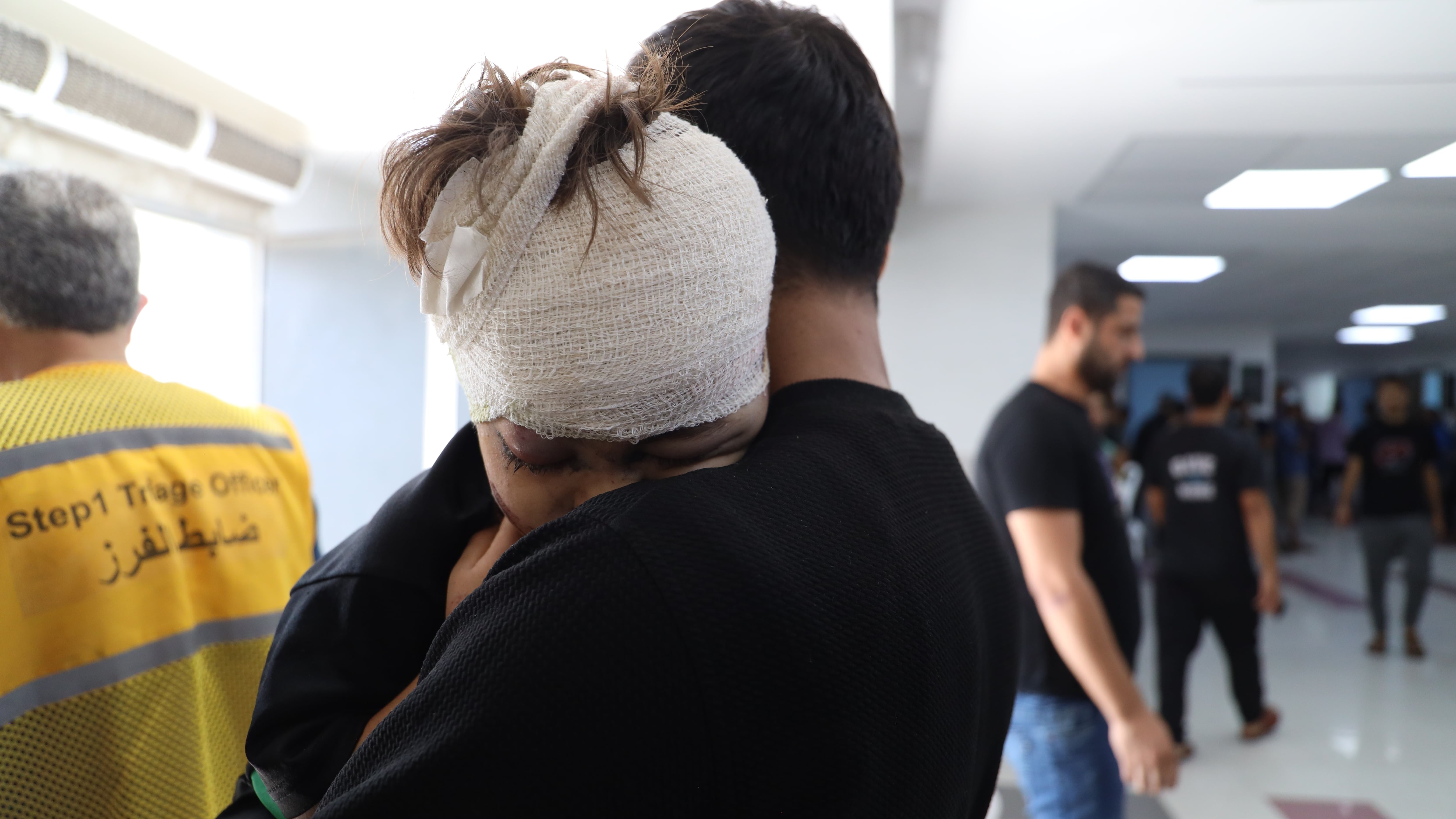 Un padre sostiene en el hospital Al Shifa de Gaza a su hijo herido por un bombardeo israelí