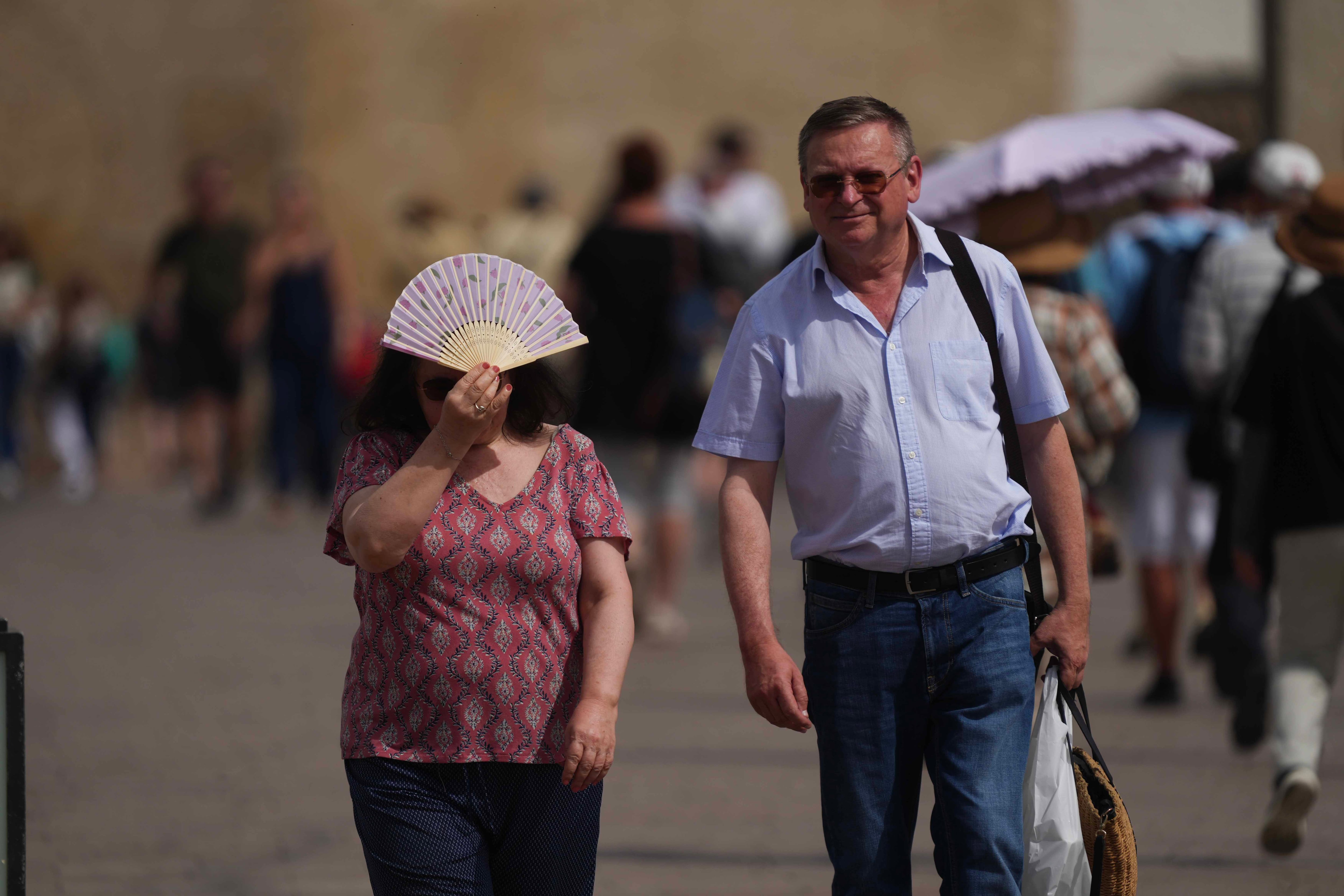 GRAFAND9172. CÓRDOBA, 10/06/2025.- Una persona se tapa un poco del sol con un abanico este martes en Córdoba, mientras media España ha activado este martes el aviso naranja o amarillo por fuertes tormentas, con chubascos, granizo grande y rachas muy fuertes de viento, por lluvias, hasta 25 litros en una hora, en Andalucía están en amarillo por calor que registrará valores que subirán hasta 38 grados, informa la Aemet en su web. EFE / Rafa Alcaide

