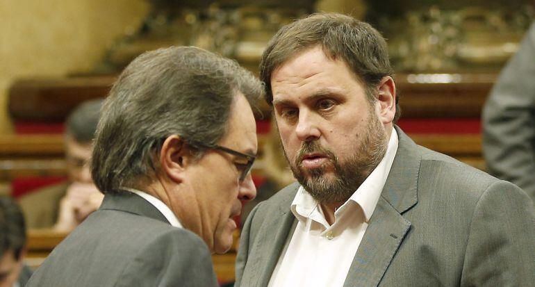 GRA090. BARCELONA, 19/12/2014.- El presidente de la Generalitat, Artur Mas (i), y el líder de ERC, Oriol Junqueras (d), conversan en el hemiciclo tras la reunión que han mantenido en el despacho del presidente catalán en el Parlament. EFE/Andreu Dalmau