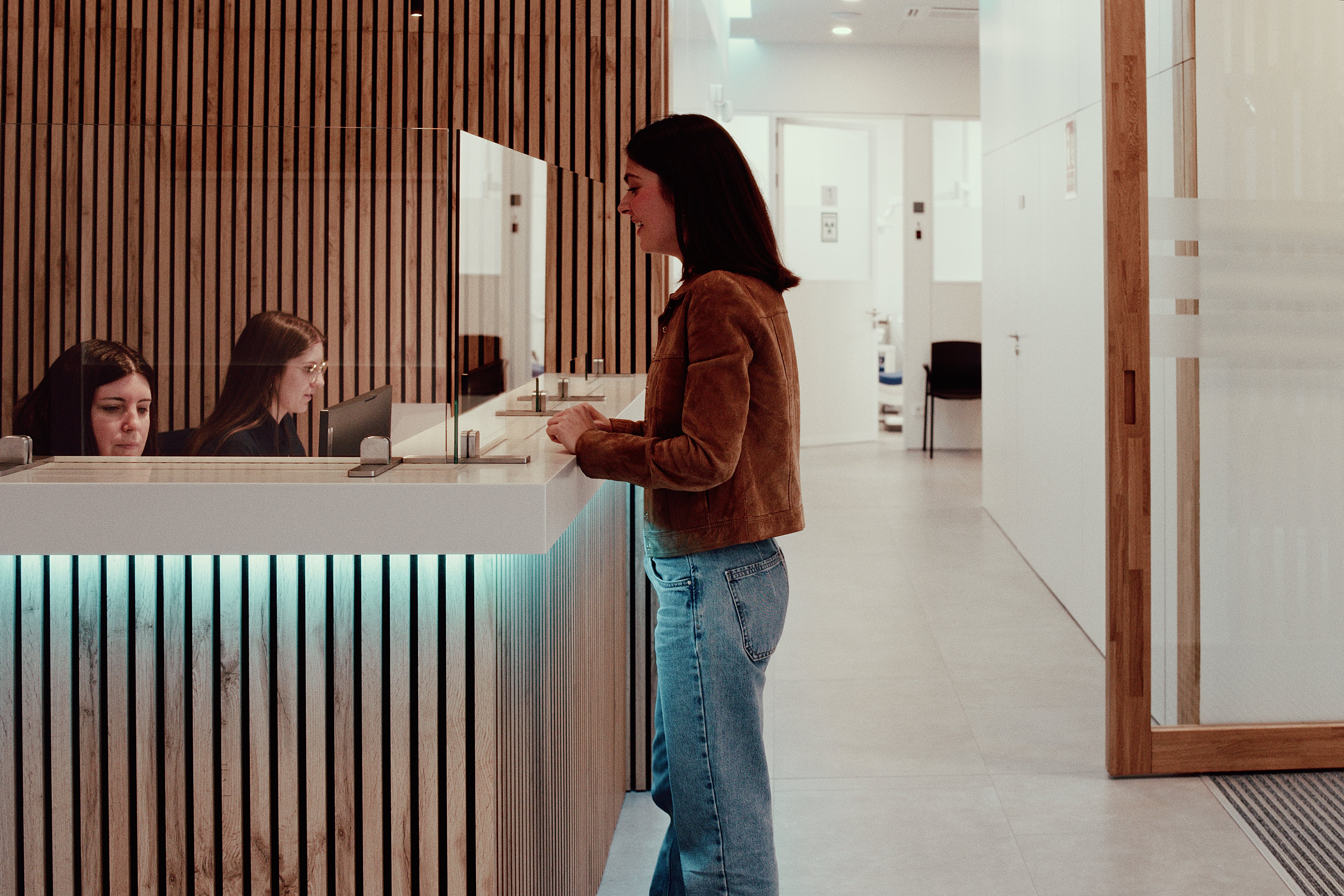 Paciente en la recepción de la Clínica Dental Bayona siendo atendida por el equipo de administración