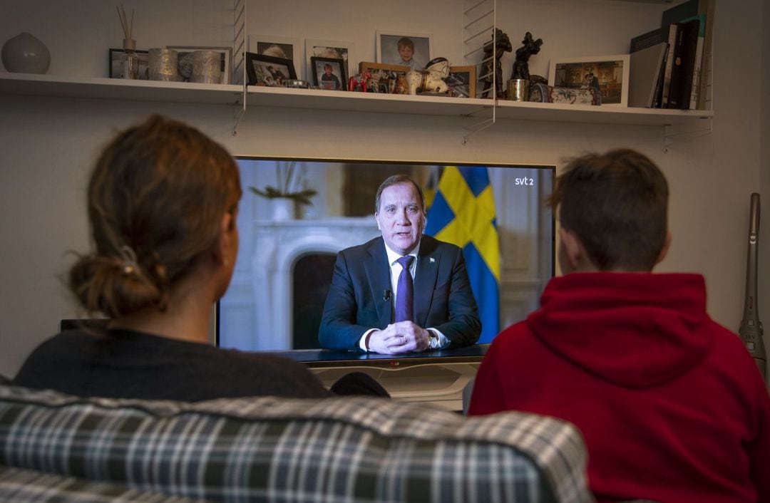 Suecos mirando en la televisión al primer ministro del país, Stefan Lofven.