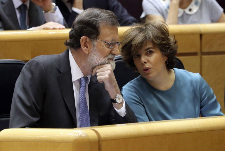  El presidente del Gobierno, Mariano Rajoy (i), conversa con la vicepresidenta, Soraya Sáenz de Santamaría (d), al inicio del pleno extraordinario del Senado convocado para aprobar las propuestas planteadas por el Gobierno para actuar contra la Generalita