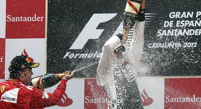 El piloto venezolano de Williams Pastor Maldonado (d) celebra en el podio junto al segundo clasificado, el piloto de Ferrari Fernando Alonso