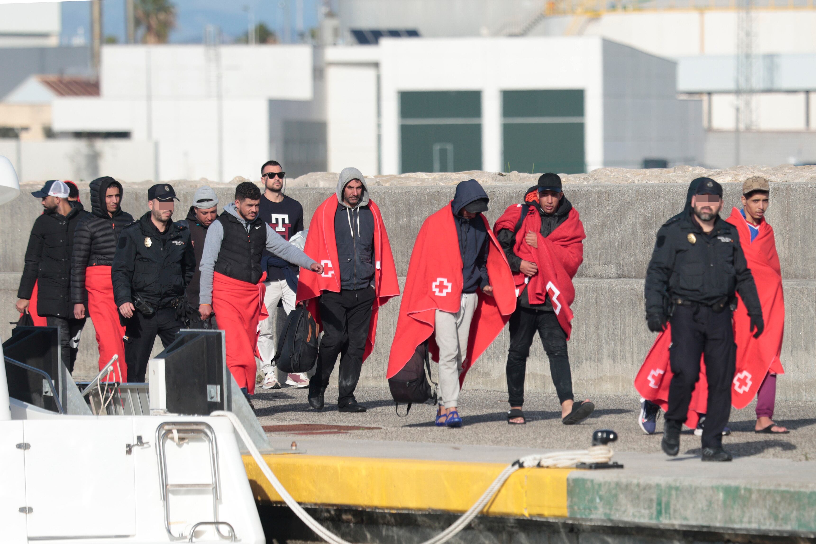 ALGECIRAS (Cádiz), 31/12/2023.- Salvamento marítimo ha rescatado a 23 personas de origen marroquí cuando intentaban llegar ilegalmente a las costas españolas. En la imagen los rescatados se dirigen al autobus para ser trasladados por la policía nacional y guardia civil. EFE/A.Carrasco Ragel.