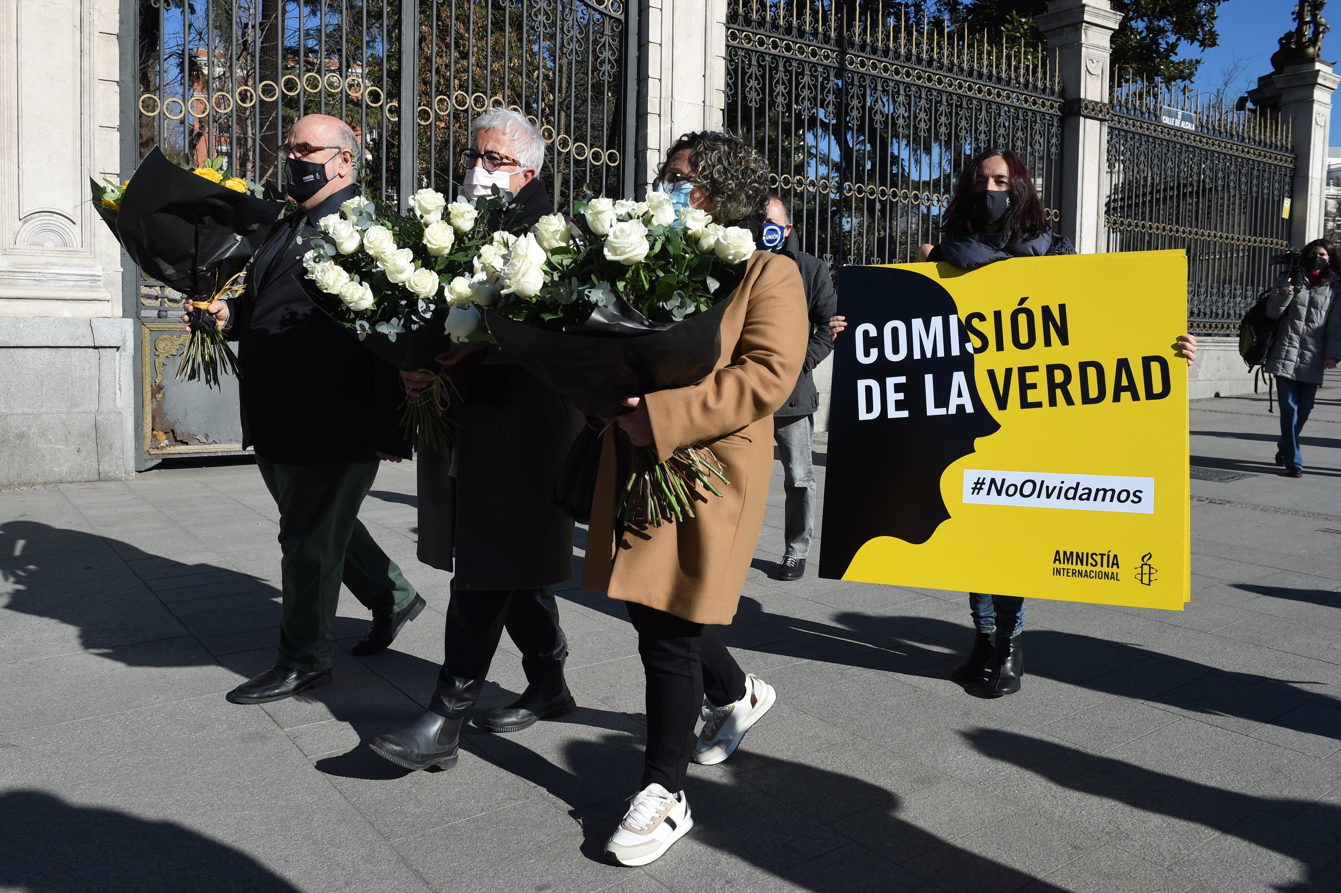 Algunos miembros de Amnistía Internacional y familias afectadas en el acto de este lunes en la plaza de Cibeles.