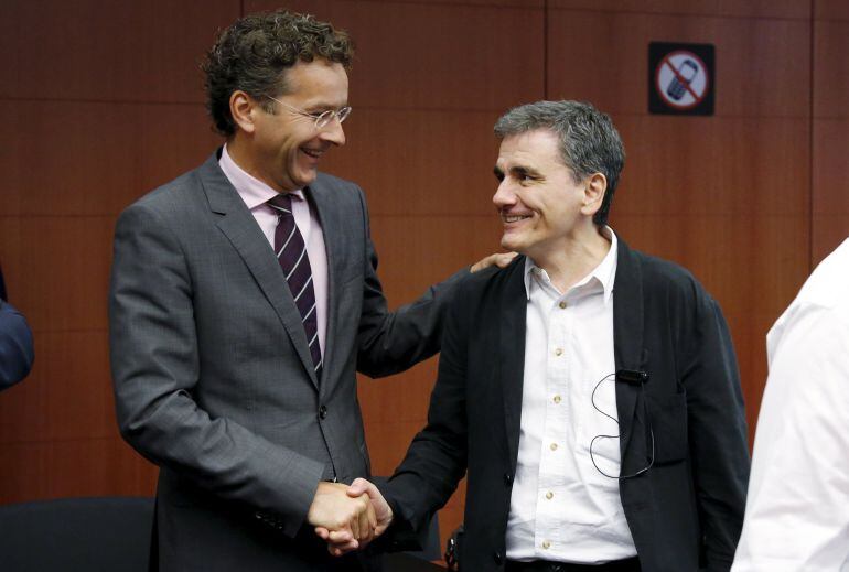 El presidente del Eurogroupo, Jeroen Dijsselbloem, estrecha la mano al ministro griego de Finanzas, Euclid Tsakalotos.