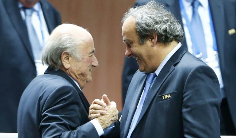 El expresidente de la UEFA, Michel Platini, felicitando al expresidente de la FIFA, Joseph Blatter.