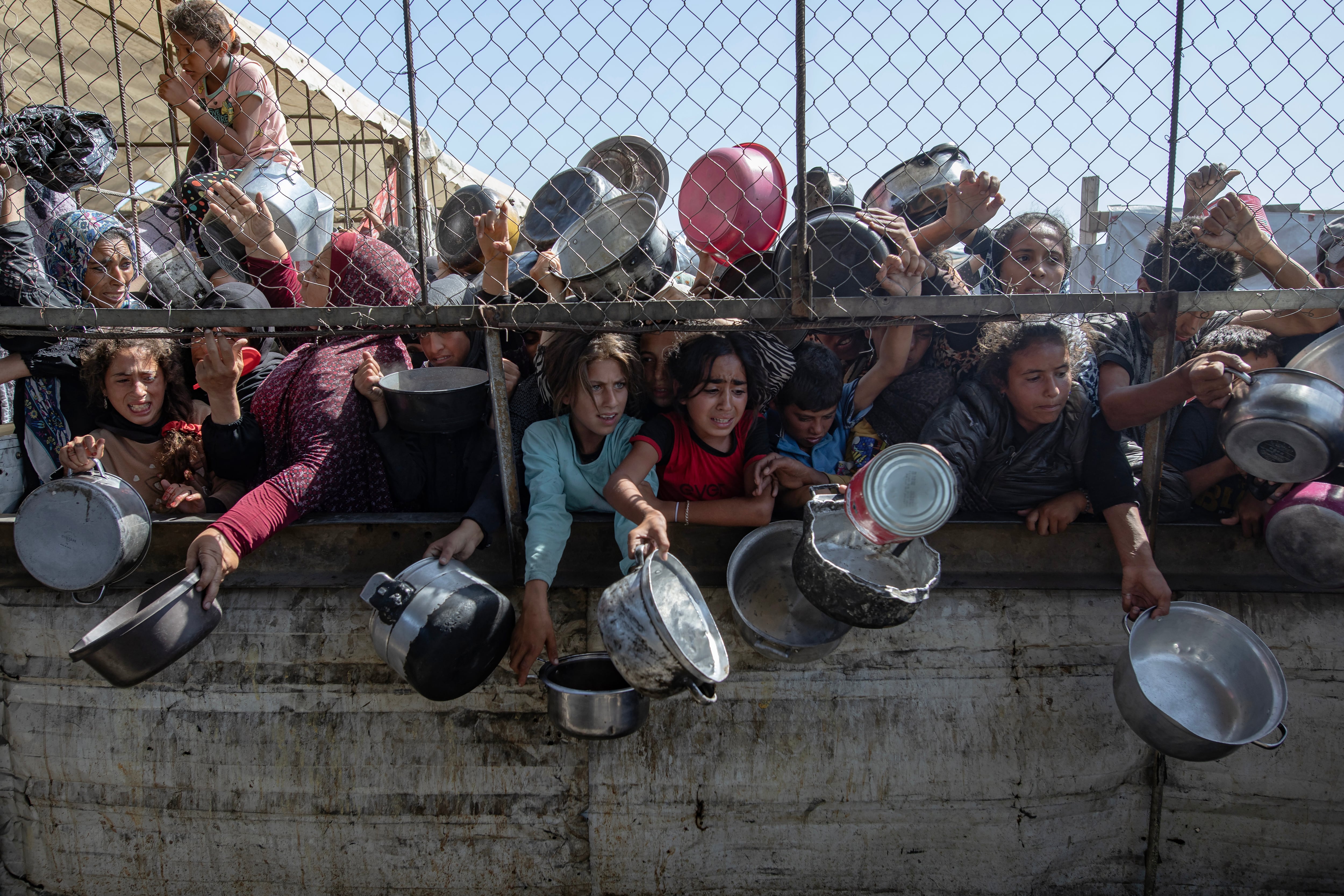 Palestinos desplazados se agolpan frente a un comedor social para recibir raciones limitadas ante la escasez de alimentos, en Khan Younis, sur de la Franja de Gaza, este viernes. EFE/ Haitham Imad