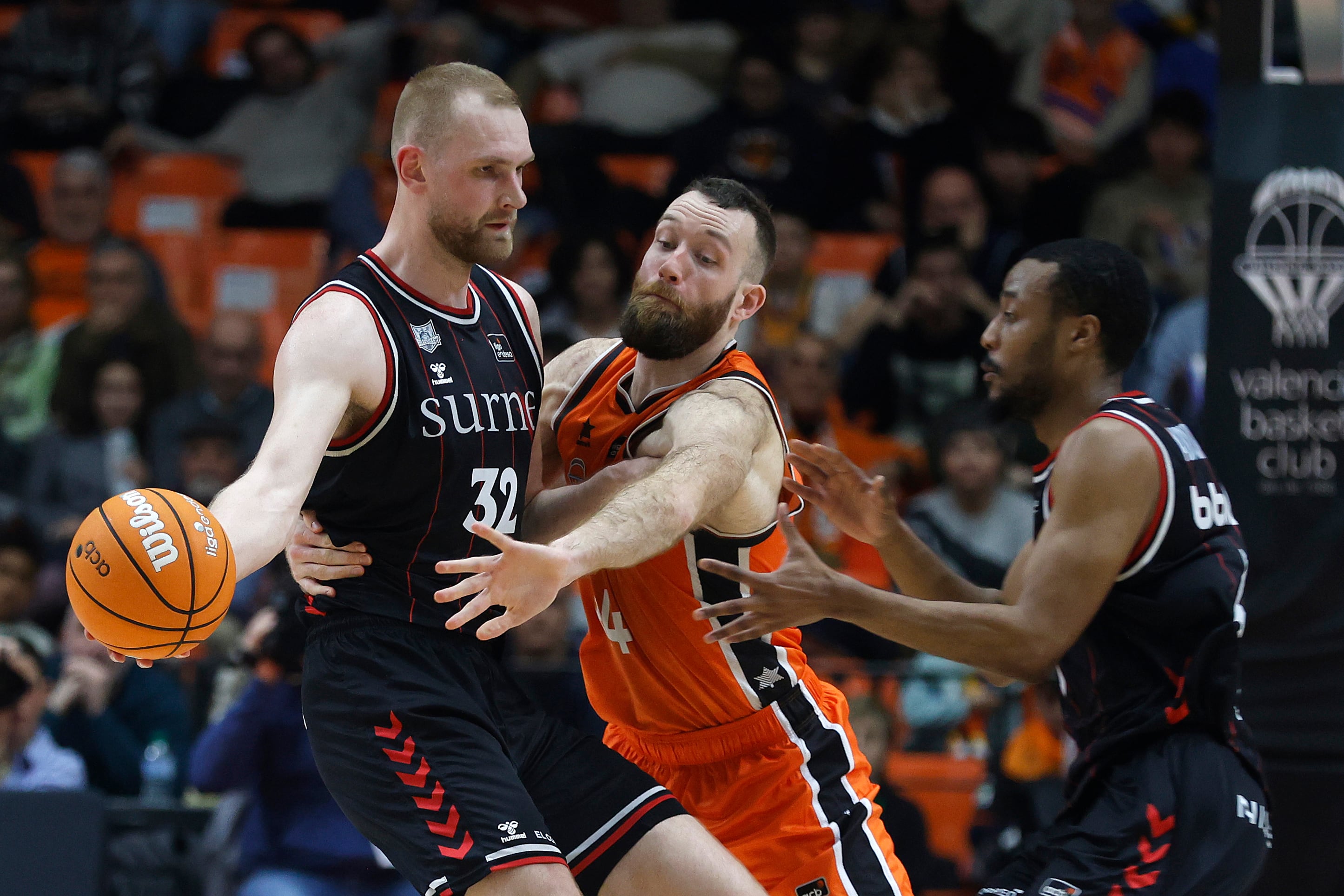 VALENCIA, 08/03/2025. El pívot islandés del Bilbao Basket Tryggvi Hlinason (i) lucha con Matt Costello (c), del Valencia Basket, durante el partido de baloncesto correspondiente a la Jornada 22 de la Liga Endesa disputado entre Valencia Basket y Bilbao Basket, hoy sábado en el pabellón de la Fuente de San Luis de Valencia. EFE/Miguel Ángel Polo
