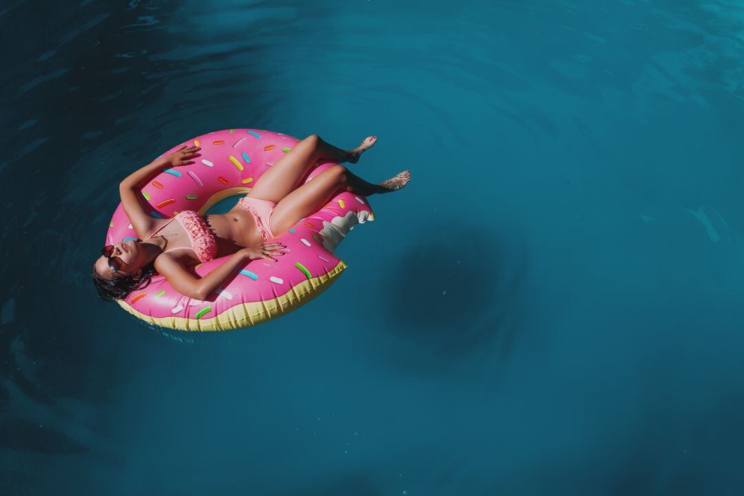 Mujer en la piscina sobre un flotador. 