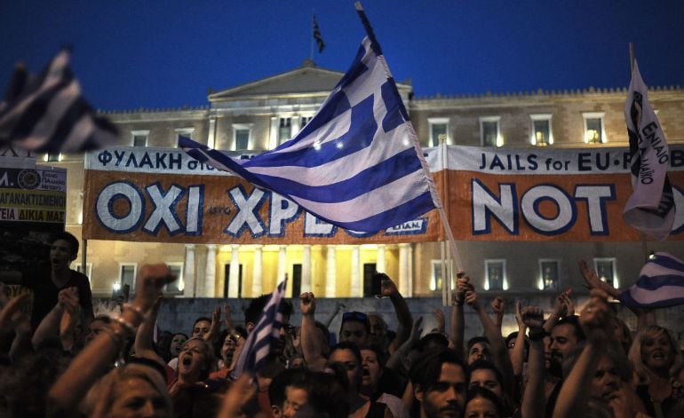 ATE04. ATENAS (GRECIA), 29/06/2015.- Manifestantes por el NO son vistos hoy, lunes 29 de junio de 2015, en la plaza Syntagma frente al edificio del parlamento griego en Atenas (Grecia). Votantes griegos decidirán en un referéndum el próximo domingo si su 