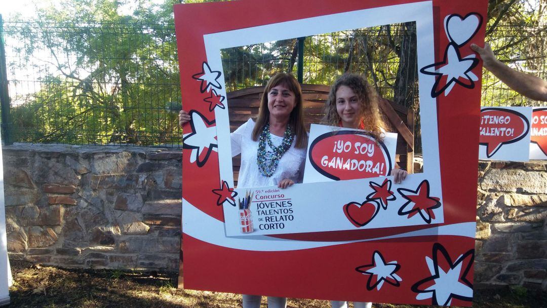 Daniela Hernando con el cartel de ganadora junto a su profesora Salomé Olmos