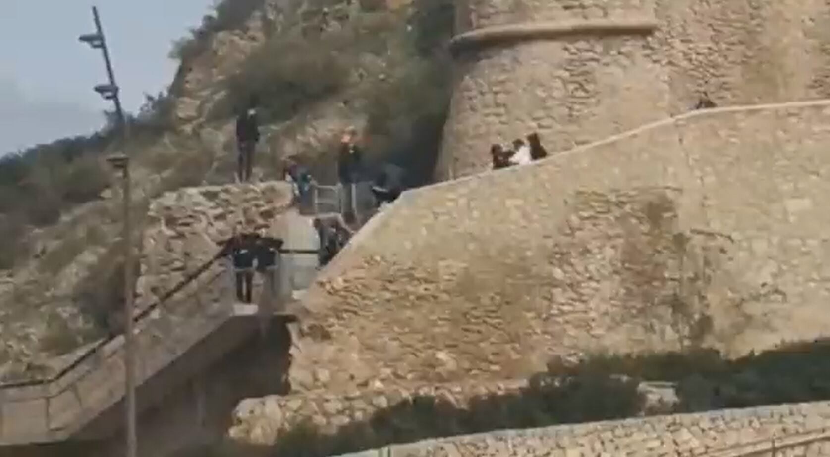 Pantallazo del vídeo en el que se ve a gente saltando la valla de la muralla del castillo de Santa Bárbara