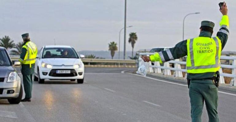 Dos guardias civiles realizan un control en una carretera.