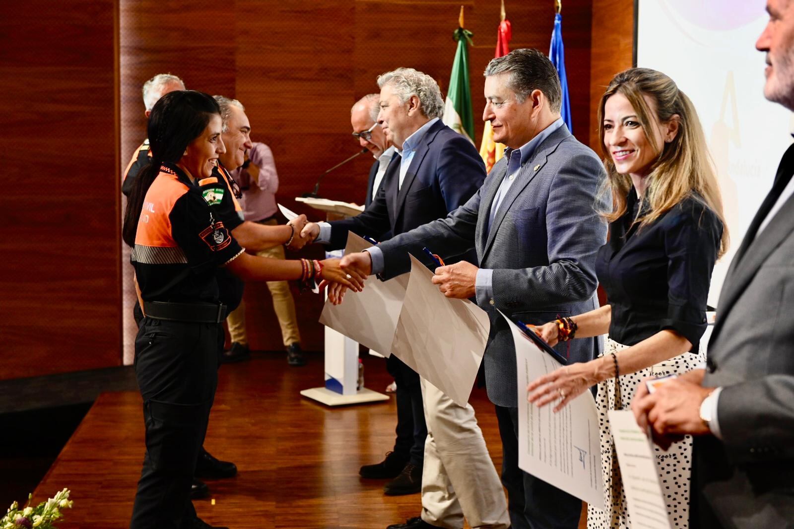 El consejero de Presidencia, Antonio Sanz, entrega un diploma a una de las voluntarias de Protección Civil durante el acto celebrado este sábado en Jaén.