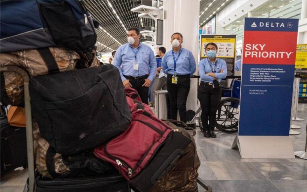 Personal de seguridad en un aeropuerto con mascarillas por el coronavirus