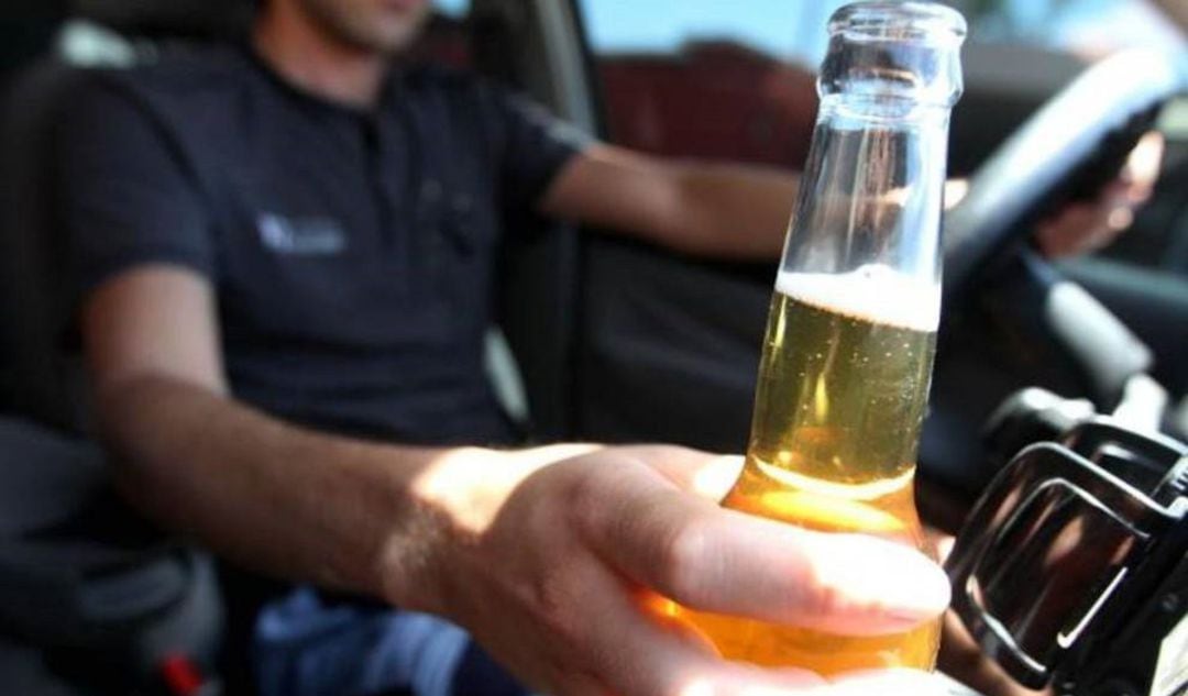 Conductor con una cerveza al volante. 