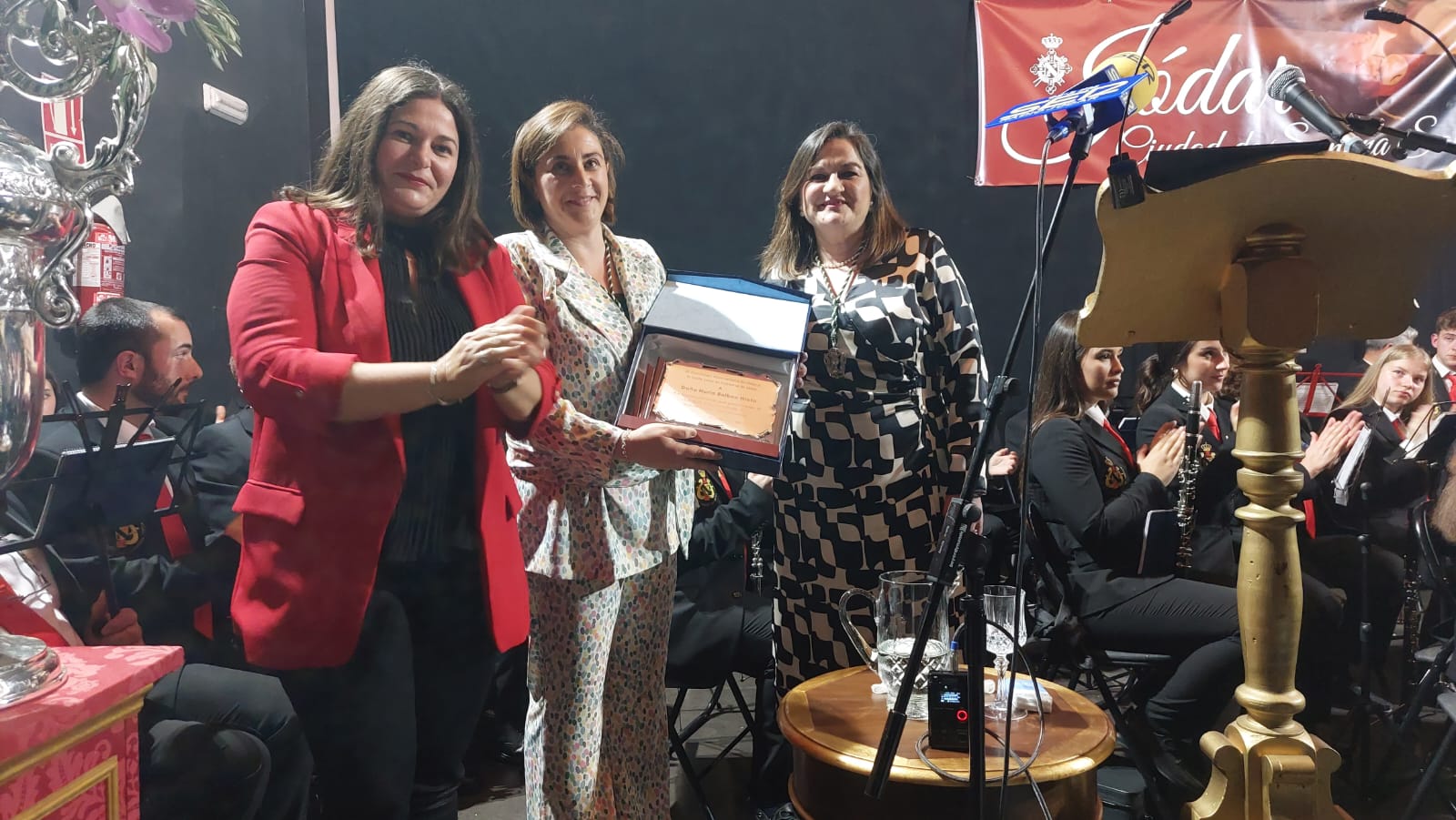 Alcaldesa, M ª Teresa García, (Izquierda) y Hermana Mayor, Juana Benítez (Derecha) entregaban la placa conmemorativa a la pregonera, Nuria Balboa (Centro)