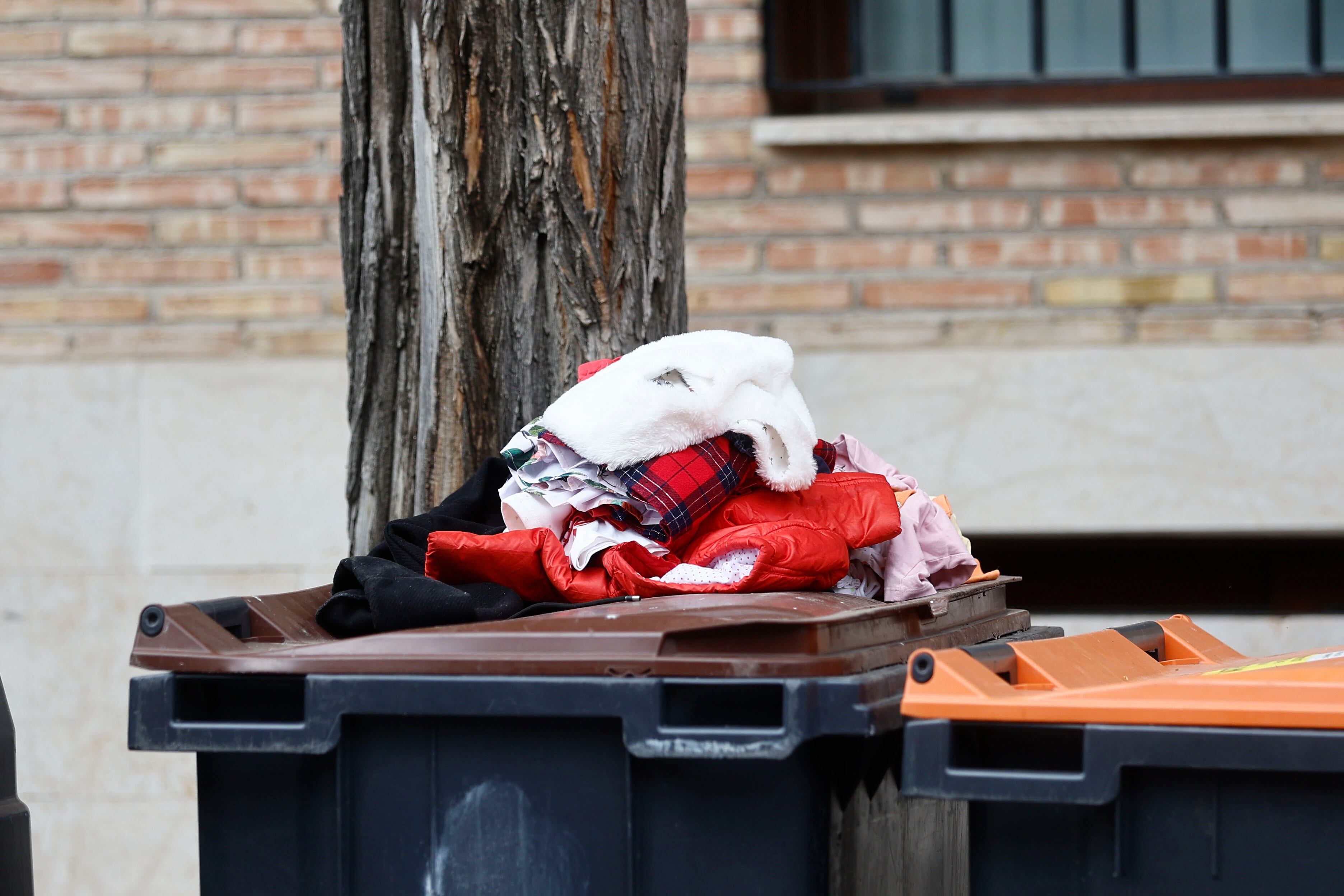 Ropa depositada encima de unos cubos de basura que la Policía Nacional investiga tras el hallazgo del cadáver de un bebé de unos tres meses entre unos cubos de basura del distrito madrileño de Barajas.