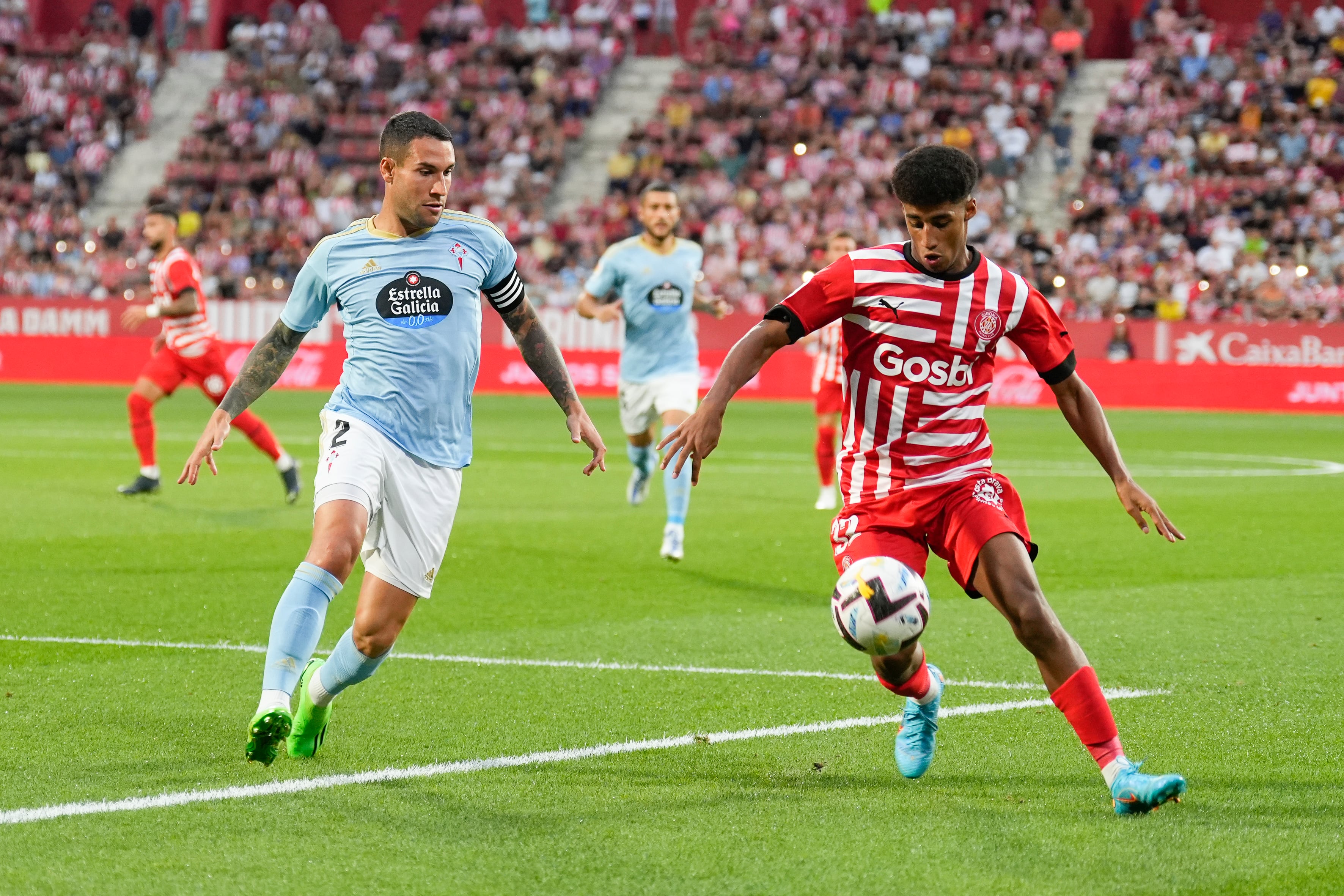 GRAF6362. GIRONA, 26/08/2022.- El jugador del Girona Óscar Ureña (d) controla el balón ante el defensa del Celta de Vigo Hugo Mallo (i) durante el partido de la tercera jornada de Liga en Primera División entre el Girona FC - RC Celta, en el estadio municipal de Montilivi. EFE/David Borrat
